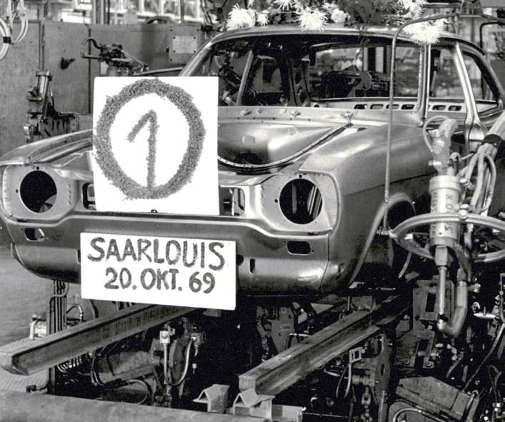 Das Ford-Werk Saarlouis wurde am 11. Juni 1970 offiziell eingeweiht. Merkwürdigerweise lief bereits am 20. Oktober 1969 die erste Rohkarosse vom Band. Der „Hundeknochen“-Escort wurde wie alle seine Nachfolger an der Saar produziert. Der Capri war im Südwesten nur ein „Nebenprodukt“, allerdings erlebte hier der einmillionste Wagen dieser Baureihe seinen Bandablauf.