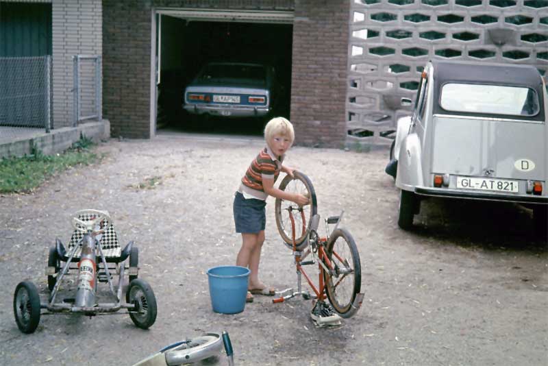 Fuhrpark der Großen und Kleinen, Dirk kümmert sich um die Fahrzeugpflege. Eine Ente - nicht diese im Bild - hatte er zu diesem Zeitpunkt bereits in einen „Totalschaden“ verwandelt.