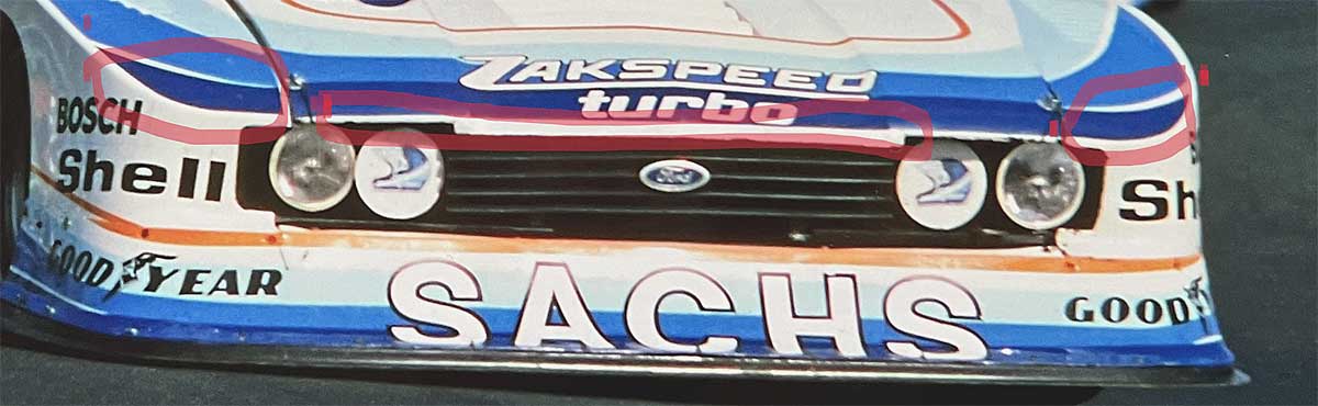 Unterschiede der Fronten bei den 79er Sachs-Capri für Detailfreunde.
Oben: Altfahrzeug (Startnummern 2/69). Dunkelblauer Streifen: starke Krümmung. Spoilerlackierung: unverändert. Weißer Strich nur auf Leiste.
Unten: Neuaufbau ab Mitte Saison 1979. Dunkelblauer Streifen: geringe Krümmung. Spoilerlackierung: verändert am Ende der Saison. Weißer dünner Strich an der Motorhaube. Unterschiede der Fronten bei den 79er Sachs-Capri für Detailfreunde.
Oben: Altfahrzeug (Startnummern 2/69). Dunkelblauer Streifen: starke Krümmung. Spoilerlackierung: unverändert. Weißer Strich nur auf Leiste.
Unten: Neuaufbau ab Mitte Saison 1979. Dunkelblauer Streifen: geringe Krümmung. Spoilerlackierung: verändert am Ende der Saison. Weißer dünner Strich an der Motorhaube.